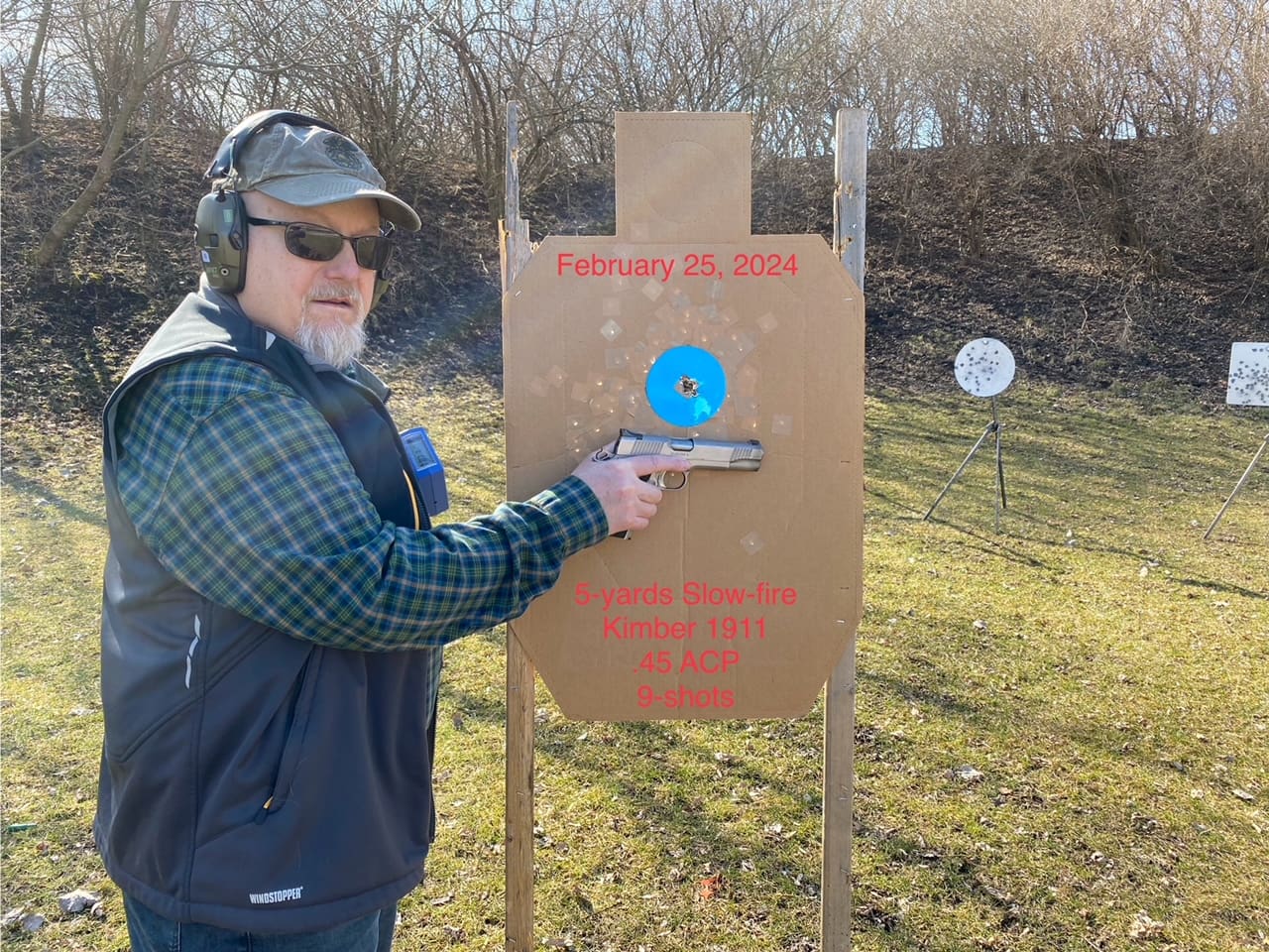 A man is aiming at an object with his gun.