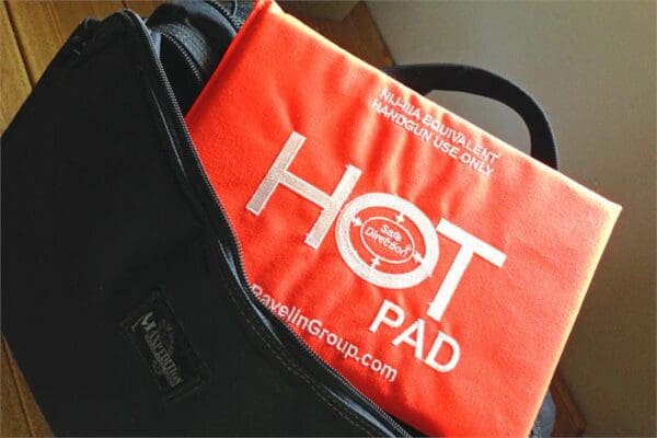 A bag of hot pads sitting on top of a suitcase.